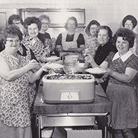Historical photo of a group of women with food